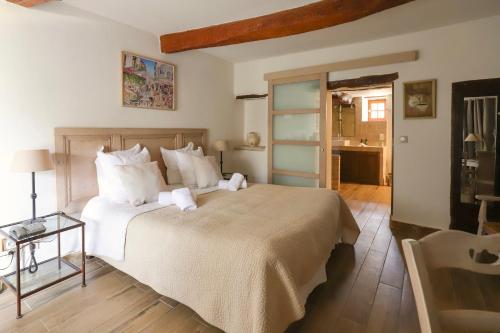a bedroom with a large bed and a table at LA FERME DE LA HUPPE in Gordes