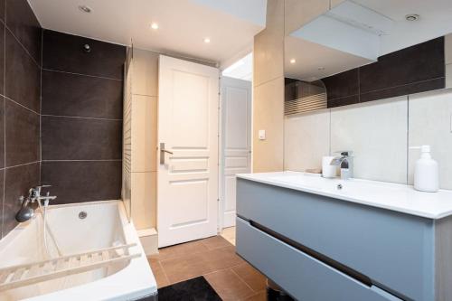 une salle de bain avec une baignoire et un lavabo dans l'établissement Appartement sous les toits 5 min du palais à pied, à Cannes