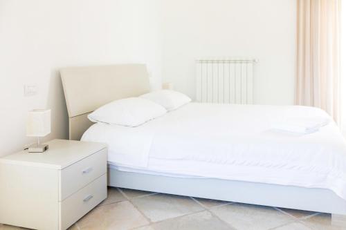 a white bedroom with a white bed and a nightstand at B&B Samarelle - Exclusive Villa with Garden and Panoramic Terrace - Molfetta in Molfetta
