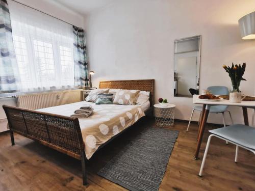 1 dormitorio con cama de mimbre y mesa en Apt 100 Prague, en Praga