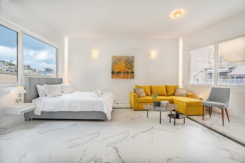 a white bedroom with a bed and a couch at Olvar's Modern Luminous Suite , Athens Downtown in Athens