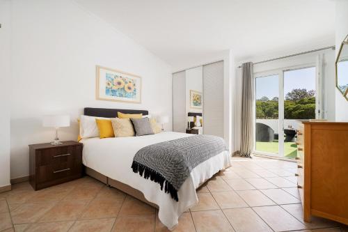 1 dormitorio con cama y ventana grande en Casa Maya - Vale do Garrão, en Quinta do Lago