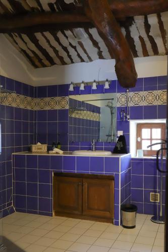 a blue tiled kitchen with a sink and a mirror at LA FERME DE LA HUPPE in Gordes