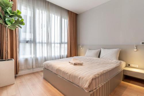 a bedroom with a large bed in front of a window at The Rixx Lancaster Apartment @ D1/ Netflix/bathtub in Ho Chi Minh City