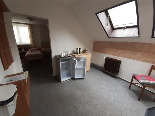 a kitchen with a small refrigerator and a window at Penzion Oráč in Velemín