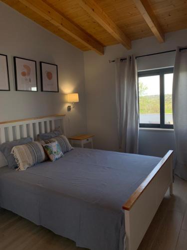 Un dormitorio con una cama grande y una ventana en Casa do Ti-Zé, en Pêra
