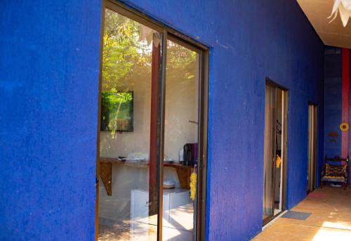 Cette chambre est dotée d'un mur bleu et d'une fenêtre. dans l'établissement La em casa Noronha, à Fernando de Noronha