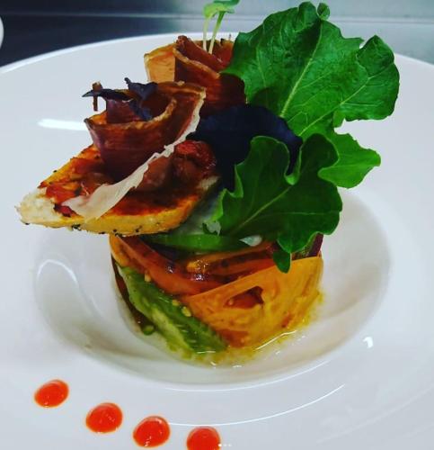 a white plate with a sandwich with greens on it at LA FERME DE LA HUPPE in Gordes