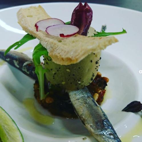 a plate of food with a sandwich and a pickle at LA FERME DE LA HUPPE in Gordes