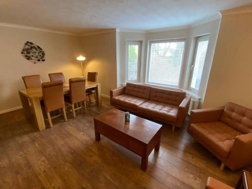 a living room with a couch and a table at 7 BR for 10 people in town in Stornoway