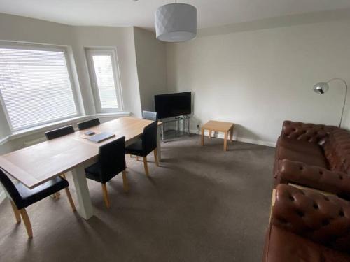 a living room with a table and a couch at 7 BR for 10 people in town in Stornoway