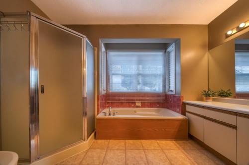 a bathroom with a tub and a shower and a sink at Fairmont Hot Springs, 3 Bedroom Vacation Home in Fairmont Hot Springs