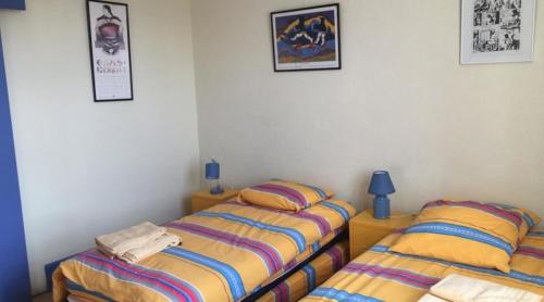 dos camas sentadas una al lado de la otra en un dormitorio en Aux baboteurs GDF, en Vallon-en-Sully