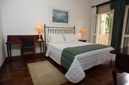 a bedroom with a bed and a desk and a desk at Don Quixote Pousada in Tiradentes