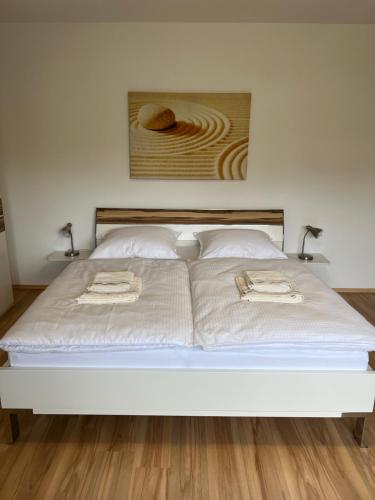 a large white bed with two towels on it at Ferienwohnung David im Haus Waldblick - Bad Bergzabern in Bad Bergzabern