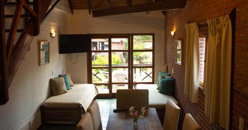 a living room with a couch and a window at Cariló Paradise Apart Hotel & Spa in Carilo