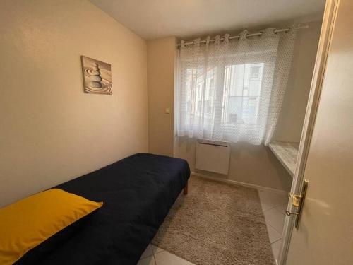 a small bedroom with a bed and a window at Appartement plein centre ville st dié des Vosges in Saint Die