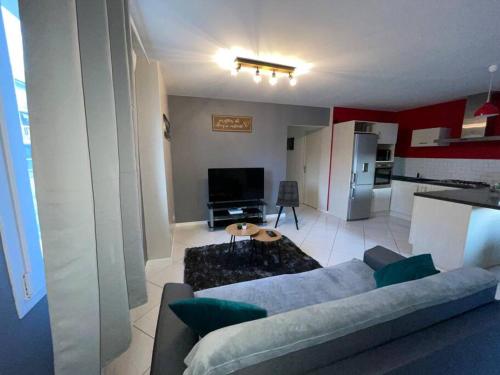 a living room with a couch and a kitchen at Appartement plein centre ville st dié des Vosges in Saint Die