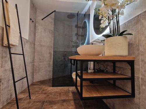 a bathroom with a sink and a shelf with a mirror at Olivea Luxury Suites in Fažana