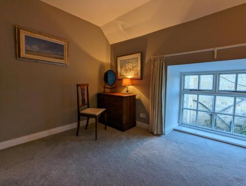 a room with a chair and a mirror and a window at The Stables at Lorum Old Rectory in Bagenalstown