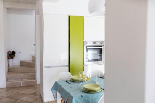 a kitchen with a table and a green wall at B&B Samarelle - Exclusive Villa with Garden and Panoramic Terrace - Molfetta in Molfetta