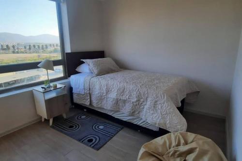 a bedroom with a bed and a large window at Departamento frente al mar in Coquimbo