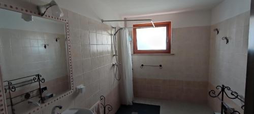 baño con ducha y ventana en Posto Tenda per gli Alpini en Pantianicco