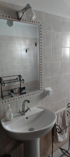 ein Bad mit einem Waschbecken und einem Spiegel in der Unterkunft Posto Tenda per gli Alpini in Pantianicco