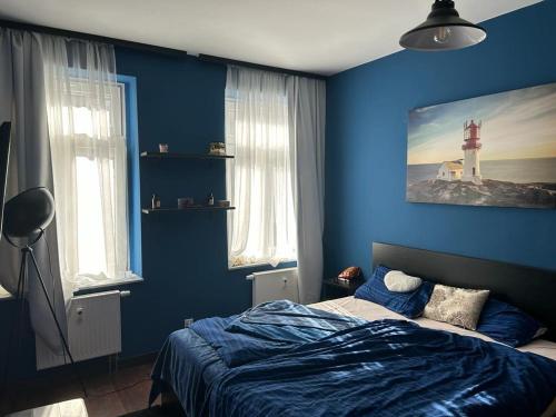FewoCompany في لايبزيغ: غرفة نوم بجدار ازرق فيها سرير ومنارة