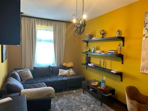 FewoCompany في لايبزيغ: غرفة معيشة مع أريكة زرقاء وجدار أصفر