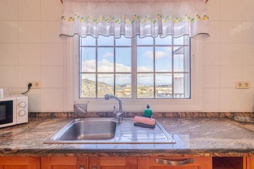 a kitchen with a sink and a window at Flatguest Villa Mayca in Santa Brígida