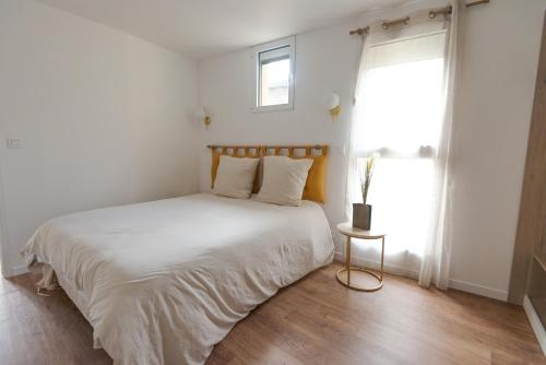 ル・トレポールにあるL'Air des Falaises - appartement confort Tréportの白いベッドと窓のある寝室