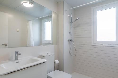 een badkamer met een wastafel, een toilet en een spiegel bij Casares Doña Julia, 3 bedrooms in Casares