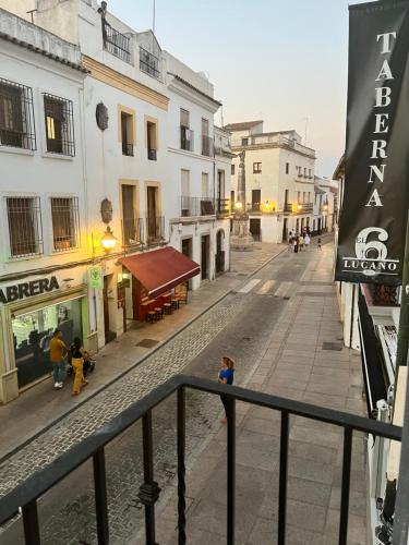 a city street with buildings and a child standing on the sidewalk at Apartamento Lucano in Córdoba