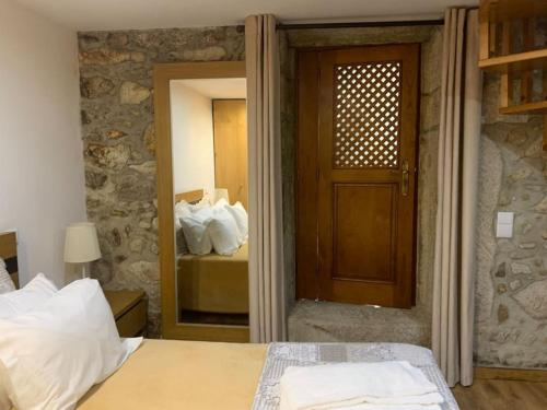 a bedroom with a bed and a door with a mirror at Quinta dos Caibrais in Porcelhe