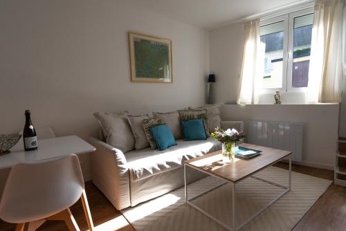 ル・トレポールにあるL'Air des Falaises - appartement confort Tréportのソファとテーブルのあるリビングルーム