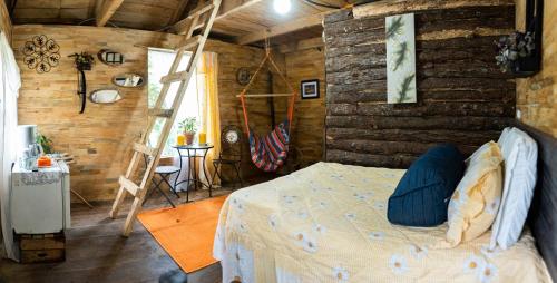 1 dormitorio con 1 cama y pared de madera en Cabaña Don Santiago, en San Cristóbal Verapaz