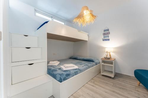 ミハスにあるSeafront Beach house Rocas del Marの小さなベッドルーム(二段ベッド1組、ランプ付)