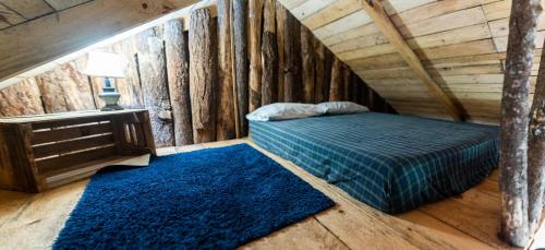 1 dormitorio con cama y alfombra azul en Cabaña Don Santiago, en San Cristóbal Verapaz