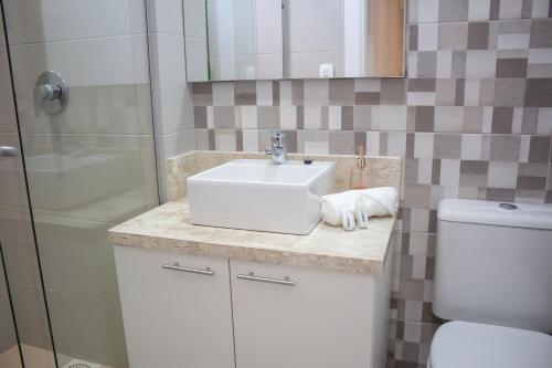 a bathroom with a sink and a toilet at Essence 516 em Atlântida in Xangri-lá
