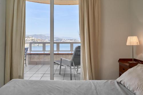 een slaapkamer met een bed en uitzicht op een balkon bij Las Lomas de Marina del Este in Almuñécar
