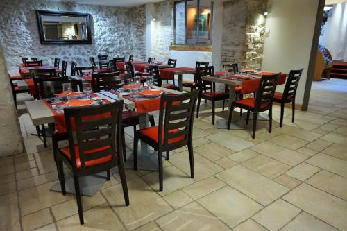 Hotel de la Couronne في إيكس لي بان: غرفة طعام مع طاولات وكراسي في مطعم