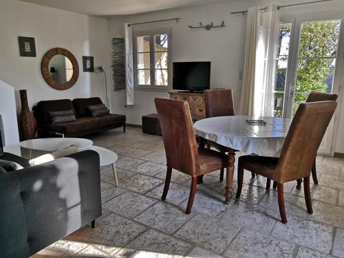 een woonkamer met een tafel en stoelen bij LA BASTIDE DES MACALO in Pont-Saint-Esprit