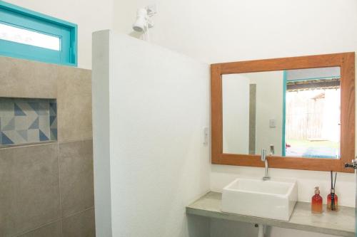 a bathroom with a sink and a mirror at CHALÉ NAMORADA PATACHO in Pôrto de Pedras