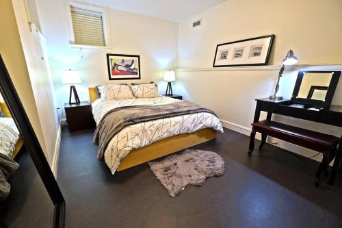 a bedroom with a bed and a table with a piano at Beautiful 1 Bedroom Garden Suite in Metrotown in Burnaby