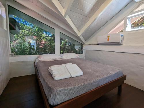 uma cama num pequeno quarto com uma janela em Linda Casa Praia de Pauba em condominio em São Sebastião