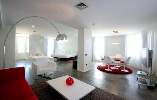 a living room with a red couch and a table at Civis Luz Castellón 4*S in Castellón de la Plana