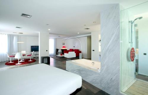 a bedroom with a bed and a bathroom with a tub at Civis Luz Castellón 4*S in Castellón de la Plana