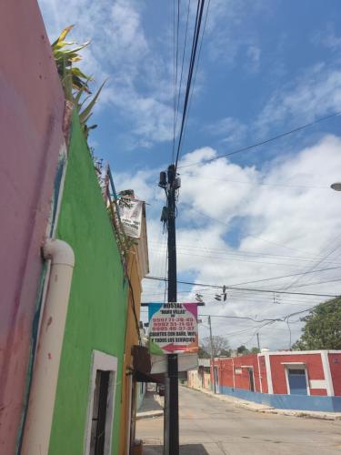 um sinal num poste em frente a um edifício em Hostal Maruvillas em Mérida