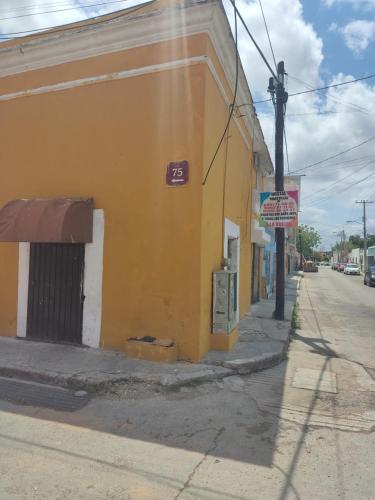 um edifício amarelo no lado de uma rua em Hostal Maruvillas em Mérida
